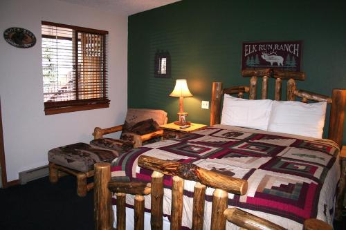 埃斯蒂斯帕克Timber Creek Chalets- 4 chalet的一间卧室配有一张木床和一把椅子