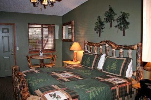 埃斯蒂斯帕克Timber Creek Chalets- 2A chalet的一间卧室配有一张床和一张带台灯的桌子