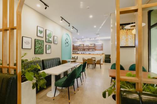富国Tropical Bay Grand World Phu Quoc的用餐室配有桌子和绿色椅子