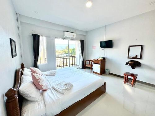 Ban Laoปัวปันสุขโฮม (Puapan Suk Home)的一间卧室设有一张大床和一个阳台