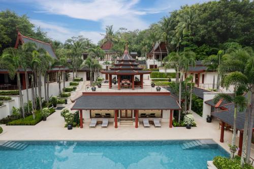 奈通海滩Trisara Villas & Residences Phuket的享有带游泳池的度假村的空中景致