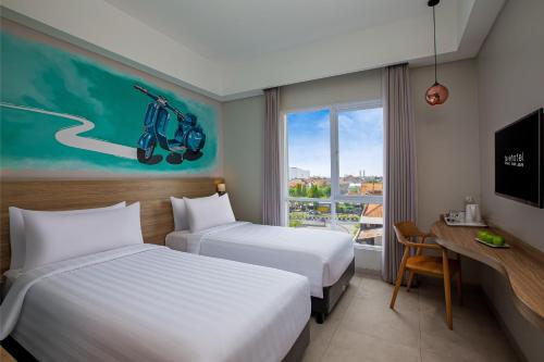 诗都阿佐favehotel Sidoarjo的酒店客房设有两张床和窗户。