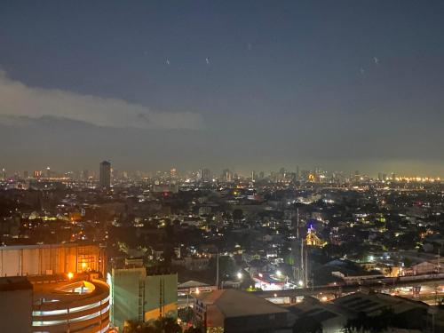 马尼拉Happy Hideout @ Grass Residences的夜晚带灯光的城市景观
