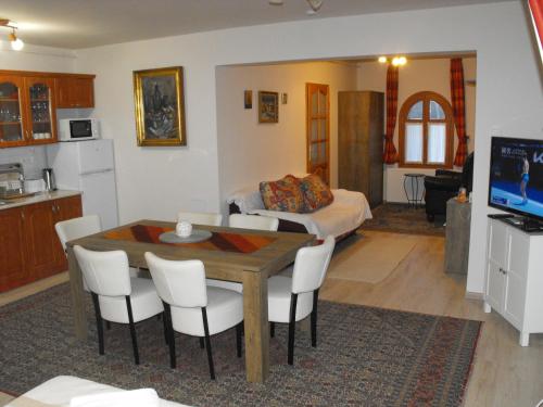 巴拉通尤洛克Ezüsthíd Apartman的厨房以及带桌子和床的客厅。