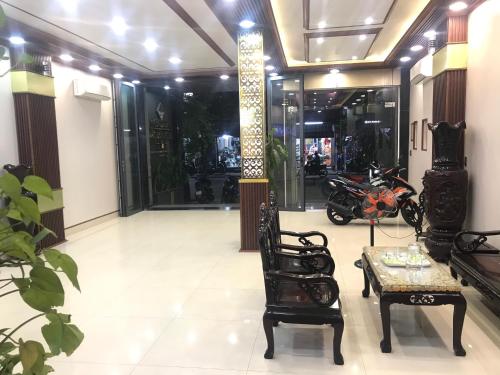顺化Đức Lộc 2 Hotel的一个带桌椅的大堂和一间带摩托车的房间