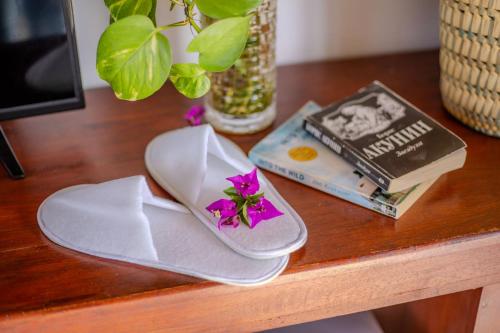 乌纳瓦图纳The Waves Unawatuna的一张桌子,上面放着一双凉鞋和一本书