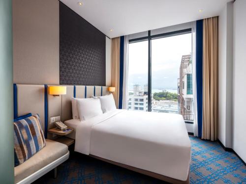 新加坡Holiday Inn Express Singapore Katong, an IHG Hotel的卧室设有一张白色大床和一扇窗户。