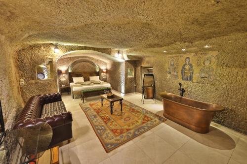格雷梅迪万岩洞酒店的洞穴内带床和沙发的房间