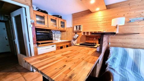 皮伊圣万桑Résidence Valgardena - Appartements pour 4 Personnes 471的房屋内的厨房配有木桌