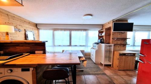 皮伊圣万桑Résidence Valgardena - Appartements pour 4 Personnes 471的厨房配有木桌和冰箱。