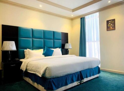 吉达فندق ميلانا Milana Hotel的一间卧室配有一张大床和蓝色床头板