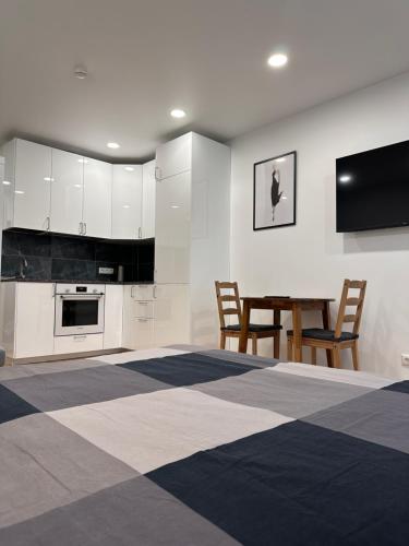 维尔纽斯OZO Life Apartment的厨房配有白色橱柜和桌椅