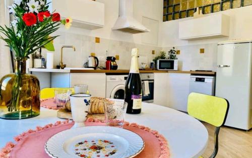 马赛Minimalistic style of Baille by Weekome的厨房配有带盘子的桌子和一瓶葡萄酒