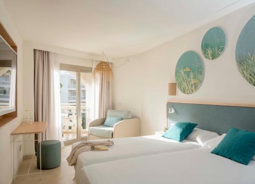 穆罗海滩Iberostar Selection Albufera Playa All Inclusive的酒店客房,配有两张床和椅子