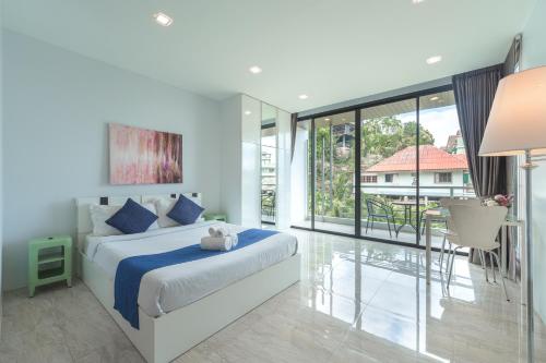 卡塔海滩3-Story Pool Villa Katazhang UTK B3 just 7 min walk to Kata Beach的一间卧室设有一张床和一个大窗户