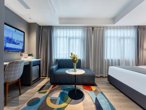 深圳兰欧酒店深圳东门罗湖口岸店的酒店客房配有床、沙发和桌子。