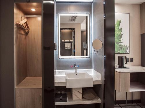 哈密尚客优品哈密皇后天街酒店的一间带水槽和镜子的浴室