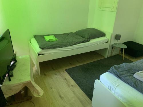 奥斯纳布吕克Gemütliche Wohnung in Osnabrück的一间小卧室,配有一张床和电视