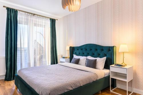 布拉索夫KOA - Sunlight Apartment的一间卧室配有一张带绿色床头板的床和窗户