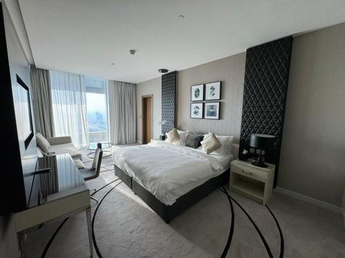 利雅德4Leisure Suites DAMAC Esclusiva Towers的一间卧室配有一张床、一张书桌和一台电视