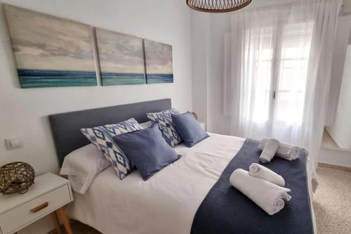 加的斯www Casa Quili Cádiz com的一间卧室配有一张带蓝色和白色枕头的床