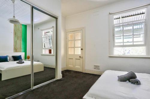 悉尼Spacious 3 Bedroom House City Centre Millers Point 2 E-Bikes Included的一间卧室配有两张床和镜子