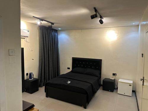 拉各斯Cozy haven apartment的一间卧室配有黑色的床和一些扬声器