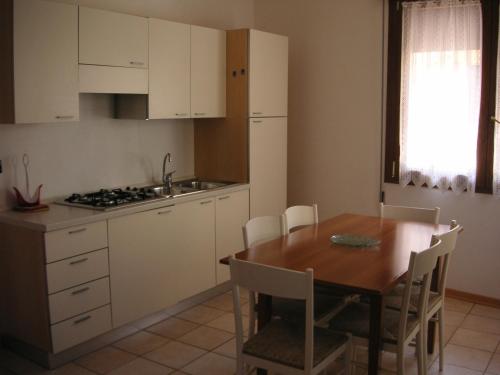 利多迪耶索罗Villa Nicole 2 camere的厨房配有木桌和桌椅