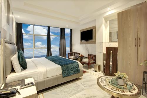 新德里Hotel International Inn - Near Delhi Airport的一间卧室设有一张大床和一个大窗户