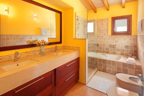 波连斯萨La Salve dalt的一间带两个盥洗盆、浴缸和卫生间的浴室