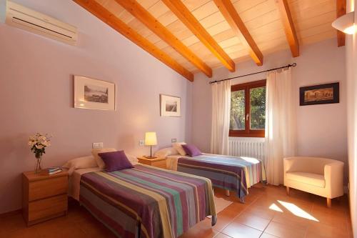 波连斯萨La Salve dalt的一间卧室设有两张床、一把椅子和一个窗户。