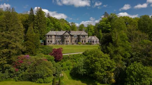 温德米尔莫热伍德乡村酒店的享有树木环绕的大房子的空中景色