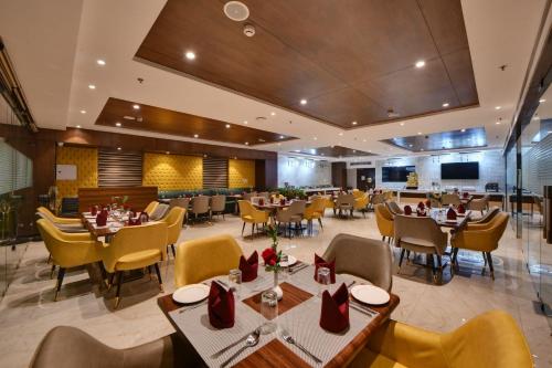 阿姆利则Quality Inn Elite, Amritsar的一间在房间内配有桌椅的餐厅