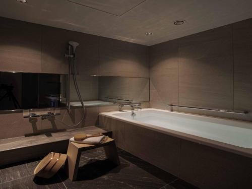 名古屋名古屋观光酒店 的带浴缸和桌子的大浴室