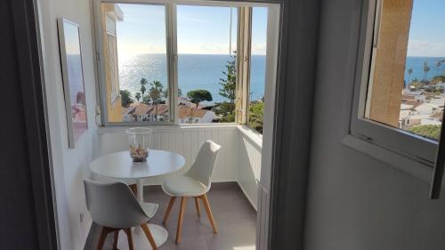 卡拉德米哈斯Loft La Cala de Mijas beach estudio mirando al mar的窗户客房内的白色桌椅
