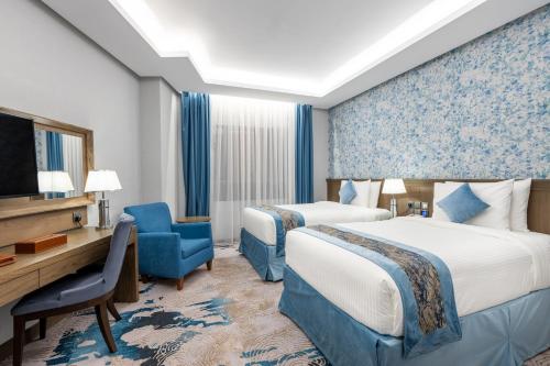 麦地那View Al Madinah Hotel的一间酒店客房,设有两张床和电视