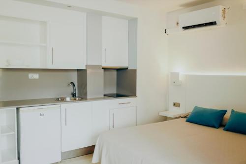 普拉亚登博萨波拉波拉公寓 - 仅限成人的白色的小厨房,配有床和水槽