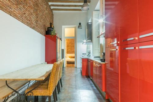 马德里Modern- 2Bd 2Bth - Ópera的厨房配有红色橱柜和木桌