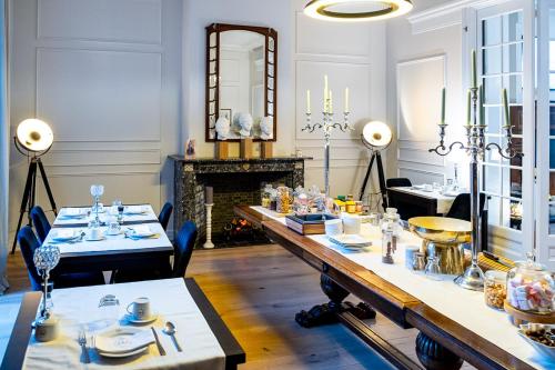 伊普尔St-Georges IV的一间带长桌和壁炉的用餐室