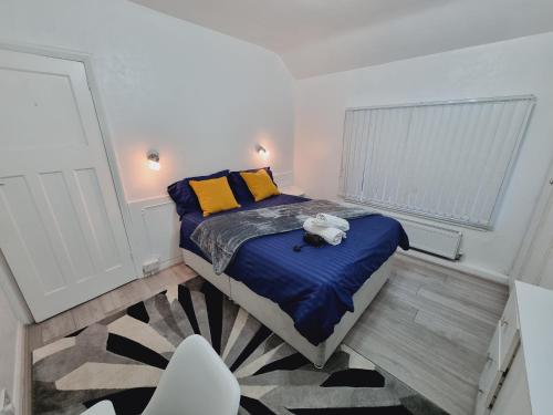 利兹Luxury double bed with Private Bathroom, NETFLIX, work space and WiFi的一间卧室配有一张带蓝色床单和黄色枕头的床。