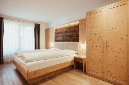 拉瓦莱Chalet La Flüta Arnica的一间卧室设有一张大床和木墙