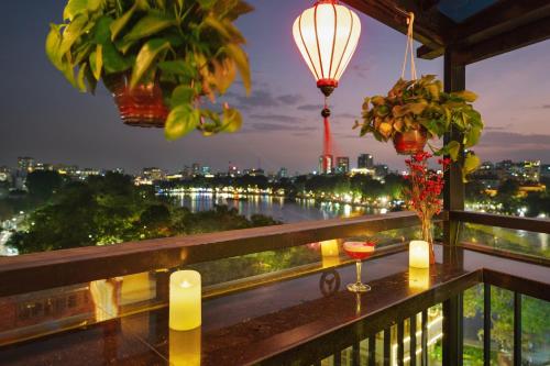 河内Bella Premier Hotel & Rooftop Skybar的享有夜间河景的阳台