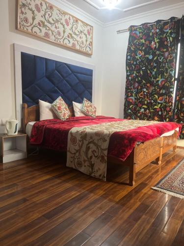 斯利那加The Light House的一间卧室配有一张带红色毯子的大床