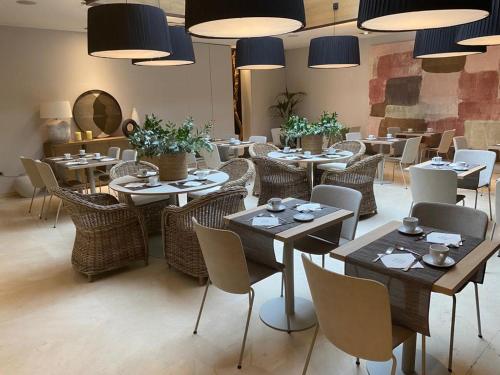 瓦伦西亚泽尼特瓦伦西亚酒店的用餐室配有桌椅和灯光