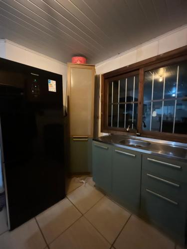 卡庞达卡诺阿Legítima casa de praia的厨房设有水槽和窗户。