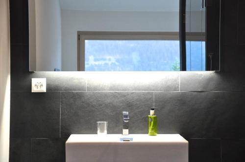 VellaPanoramic Ecodesign Apartment Obersaxen - Val Lumnezia I Vella - Vignogn I near Laax Flims I 5 Swiss stars rating的浴室设有白色水槽和镜子