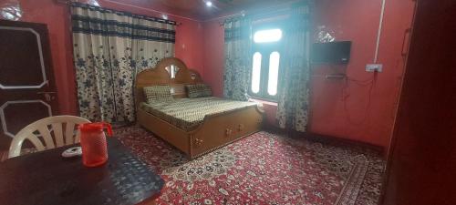 BhadarwāhKRISHNA HOMESTAY的一间卧室配有一张床、一张桌子和一个窗户。