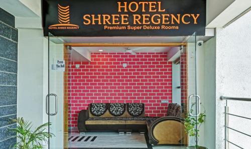 艾哈迈达巴德Hotel Shree Regency, Ahmedabad的砖墙前有两长凳的商店前