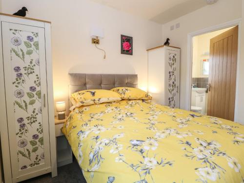 费克纳姆The Annexe的一间卧室配有黄色的床,床上有鲜花