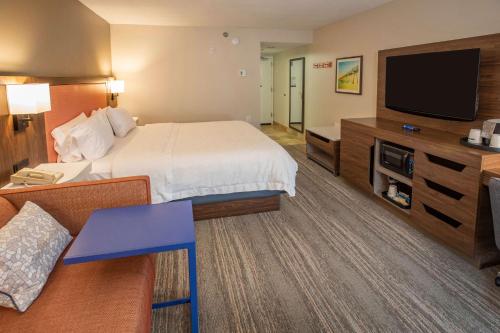 彭萨科拉彭萨科拉机场汉普顿酒店的配有一张床和一台平面电视的酒店客房